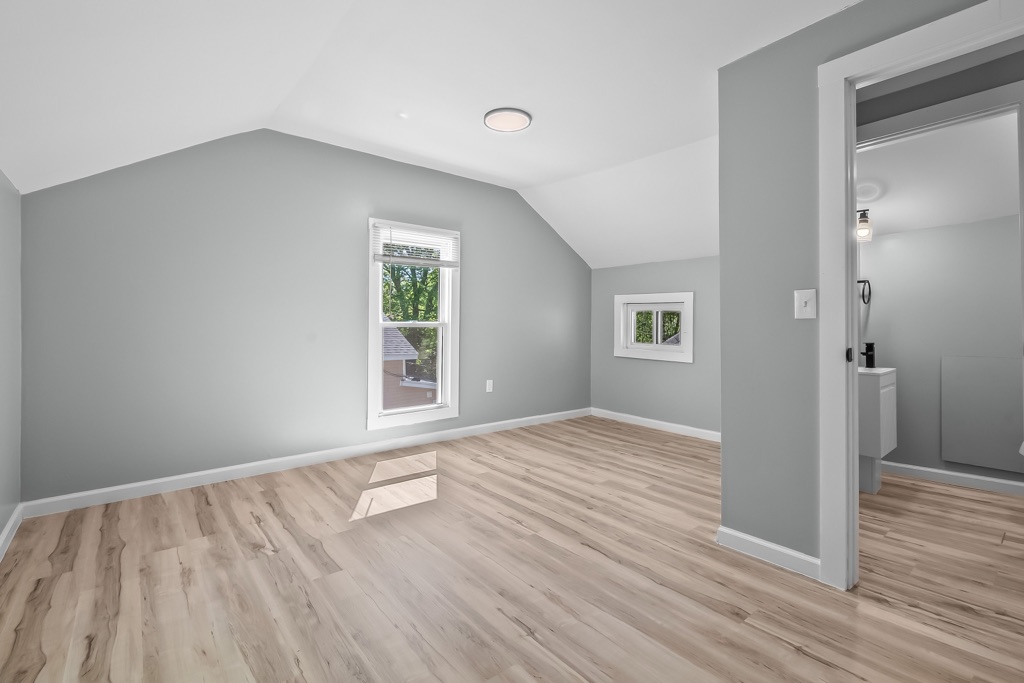 Upstairs bedroom after renovation under the sloped ceiling, bathroom through the door.