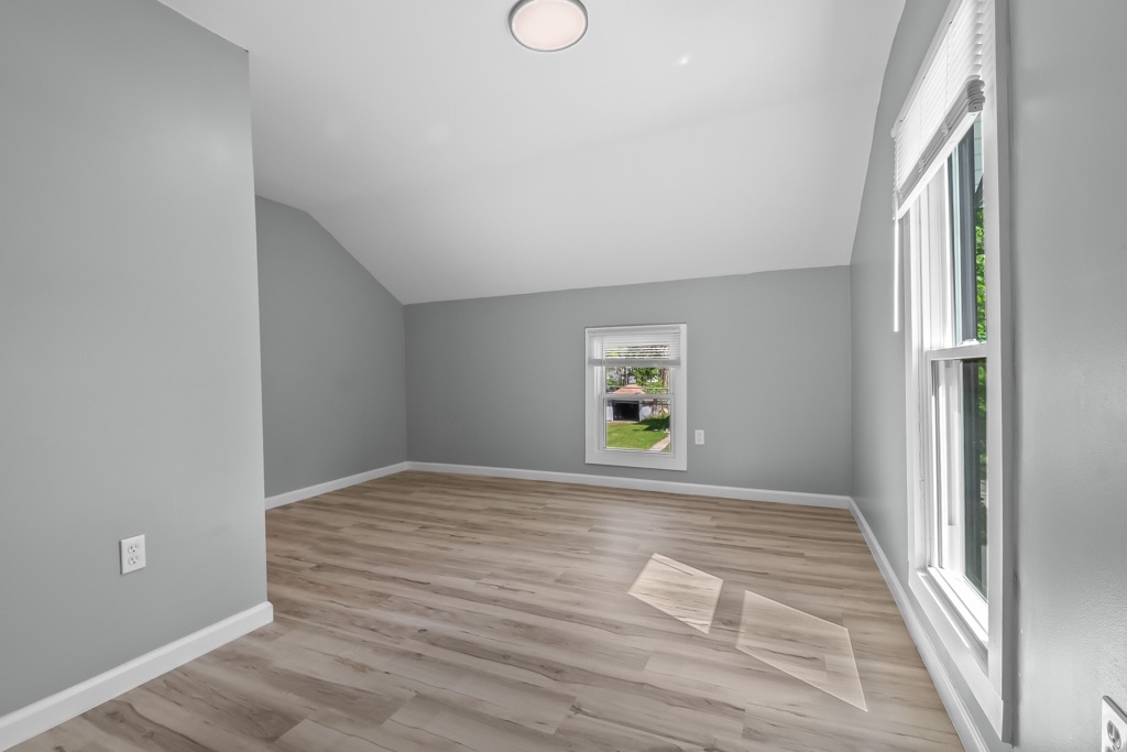 Upstairs room after renovation: new flooring, fresh paint, window over the yard.